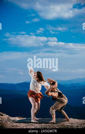 Two athletic young dancers making a performance at mountain peak Stock Photo