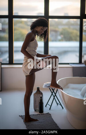 Slim dark-skinned woman enjoying spa procedures at home Stock Photo