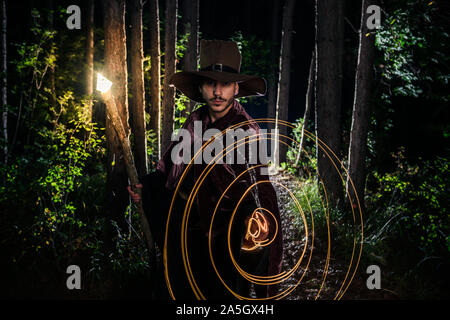 Man wizard with pendulum in black costume and hat for Halloween Stock Photo