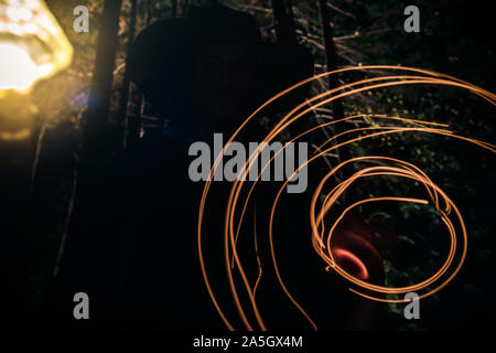 Fantasy wizard making magical circle speells with his pendulum in the woods during midnight Stock Photo