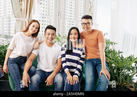 Two happy young Asian couples in casual clothes spending time together Stock Photo