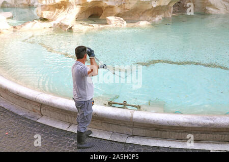 ROME, ITALY - SEPTEMBER 16, 2019: city worker collecting money and doing special cleaning of Trevi Fountain in Rome, Italy. Stock Photo