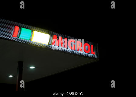 Agno, Ticino, Switzerland - 2nd October 2019 : View of the luminous Migrol gas station in Agno, Switzerland. Migrol is a company owned by Migros, the Stock Photo