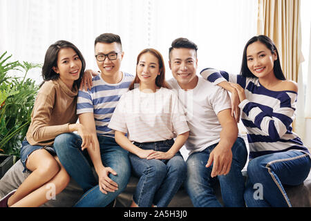 Group of friends leaning on each other when posing together for photo Stock Photo