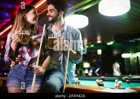 Happy young man playing snooker with his girlfriend. Happy loving couple. Stock Photo