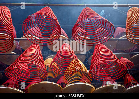 Burning incense spirals hanging from ceiling in Tin Hau Temple Complex. Yau Ma Tei, Kowloon, Hong Kong. Stock Photo