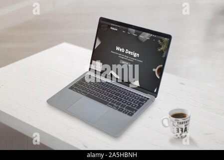 Web design studio concept web page on laptop. Clean scene with cup of coffee beside. Web development or design studio concept. Stock Photo