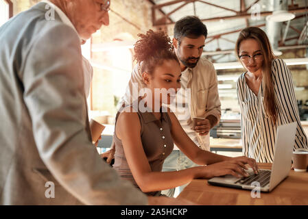Successful team. Business people looking at the laptop while working together in the modern office Stock Photo