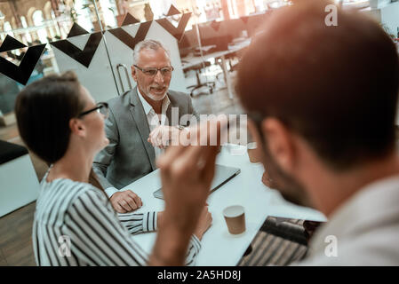 Office workers. Group of business people discussing something while sitting at the office table together Stock Photo