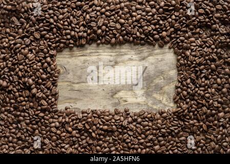 Overhead shot of a coffee beans frame over a wooden surface great for background or writing text Stock Photo