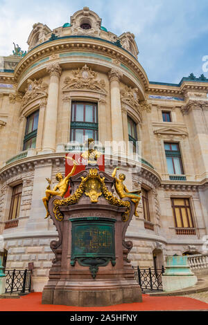 Close portrait view of the Pavillon de l'Empereur at the West façade of the Palais Garnier in Paris. The golden monument of Charles Garnier on a red... Stock Photo