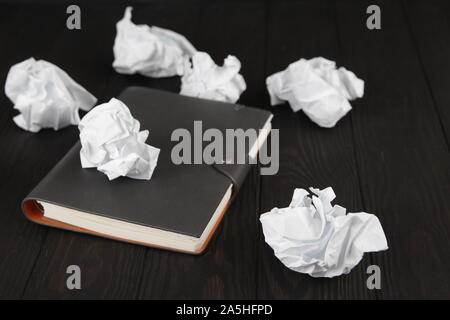 Empty notebook and crumpled paper balls on grey table, flat lay. Space. For text. Stock Photo