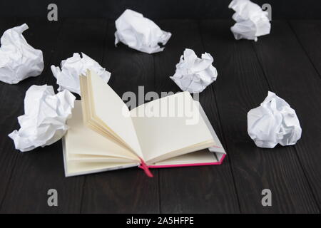 Empty notebook and crumpled paper balls on grey table, flat lay. Space. For text. Stock Photo