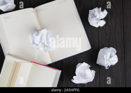 Empty notebook and crumpled paper balls on grey table, flat lay. Space. For text. Stock Photo