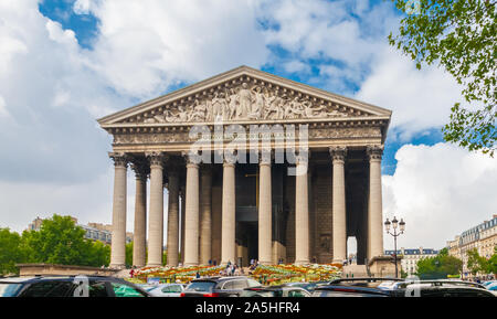 Full front view of the La Madeleine church with its Corinthian columns and sculptural pediment in Paris. It is built in the Neo-Classical style and...