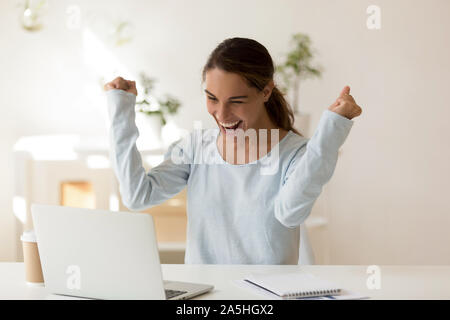 Euphoric laughing mixed race millennial female student making yes gesture. Stock Photo