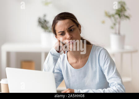 Unhappy stressed young mixed race woman stuck with hard task. Stock Photo