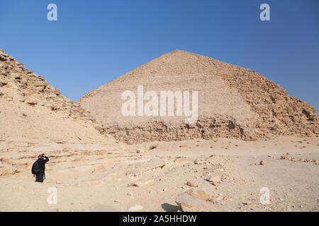 Egypt, Dashur, Sneferu's Bent Pyramid and a tourist taking a photograph.. Stock Photo