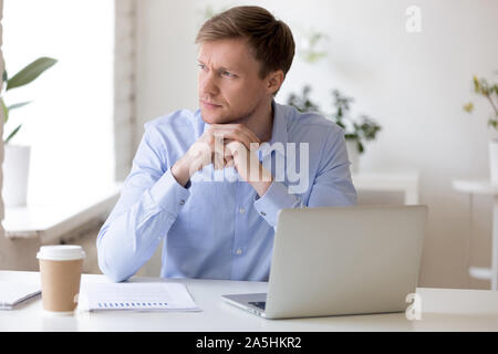 Pensive businessman distracted from job looking away. Stock Photo