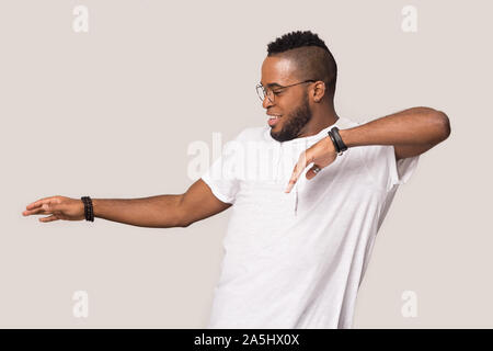 Overjoyed african American man dancing in grey studio Stock Photo
