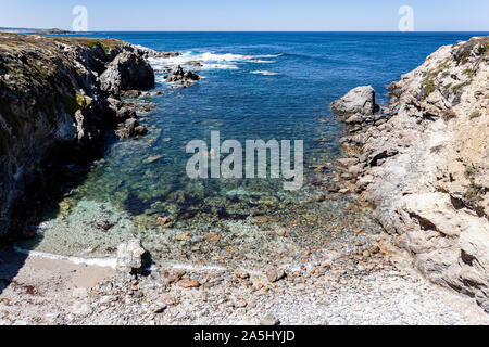 Rolled stones beach protected by cliffs of the Alentejana coast in Portugal. Stock Photo