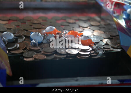 2p coins stacked inside a tuppenny nudge (tipping point) machine at seaside amusement arcade, vintage coin-operated slider game, 2019 Stock Photo