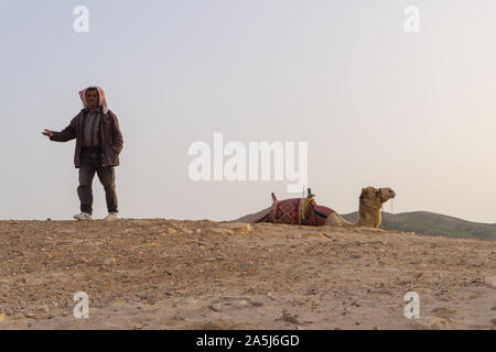 Judean desert, Israel- February 26, 2018: a Bedouin with a camel in the desert Stock Photo