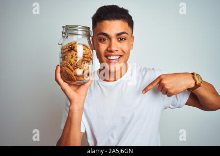 Young Brazilian Man Holding Jar With Italian Dry Pasta Over Isolated 