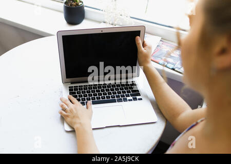 Girl working with laptop, focus on computer. Stock Photo