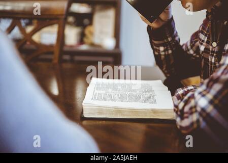 Closeup shot of a male reading a book while drinking coffee with a blurred background Stock Photo