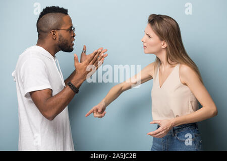 Angry multiracial couple engaged in fight having relations problems Stock Photo