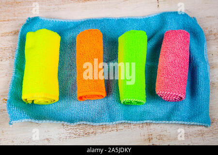 Multi-colored rags for cleaning on a wooden background. Stock Photo