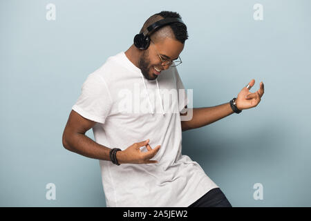 Overjoyed biracial man in earphones have fun dancing Stock Photo