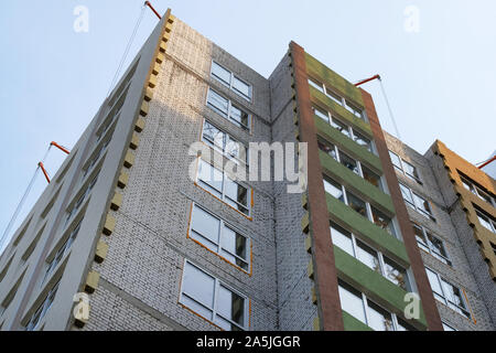 Building and Construction site of new home. Mineral wool for insulated house. Facade of many story new house under construction. Stock Photo