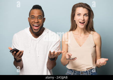 Shocked multiracial man and woman overjoyed with online offer Stock Photo