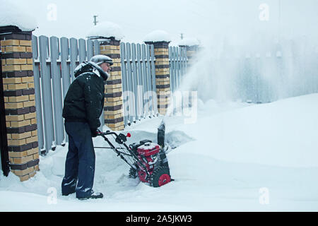 Snow clearing. Snowblower clears the way after heavy snowfall. Stock Photo