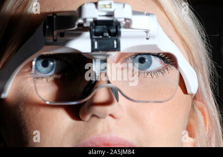 young female person using magnifying glasses headset Stock Photo