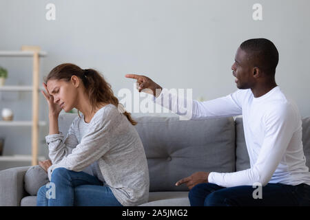 Annoyed woman ignore mad african American husband scolding Stock Photo