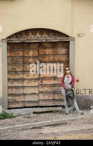 Girl standing next to wooden door of an old house in Tokarnia open-air ...