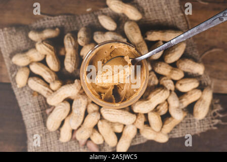 Peanut butter,groundnut and spoon on a wooden table. Concept of breakfast food and peanut butter lover Stock Photo