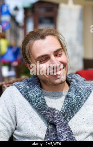 Portrait of handsome smiling man wearing grey sweater. Stock Photo