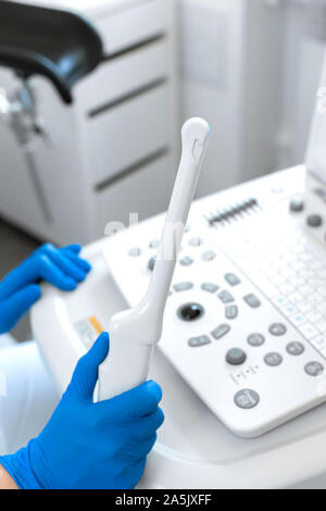 A gynecologist sets up an ultrasound machine. A transvaginal ultrasound scanner of the internal organs of the pelvis. Female health concept. Stock Photo
