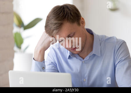 Head shot close up middle aged tired entrepreneur feeling sleepy. Stock Photo