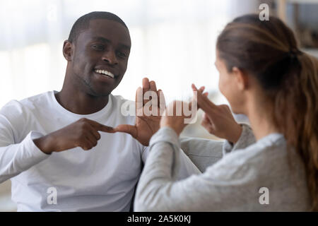Smiling multiracial friends talk using sign language Stock Photo