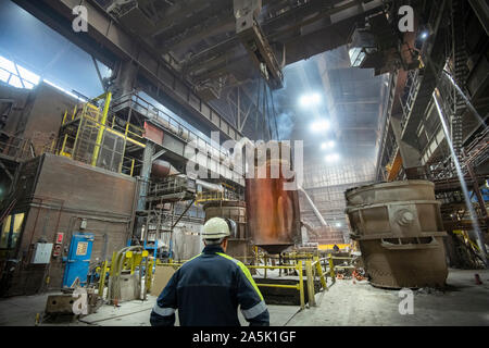 200 ton red hot steel ingot being lifted from mould in steelworks