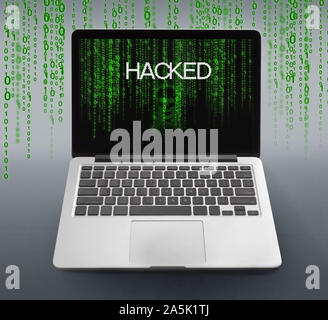 Laptop with hacked message and binary code numbers on screen Stock Photo