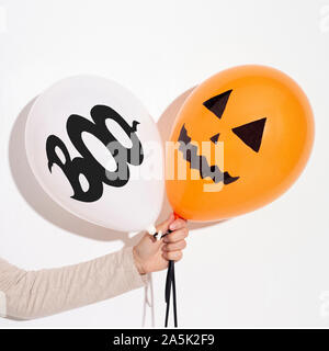 Woman holding Halloween balloons in hand for party Stock Photo