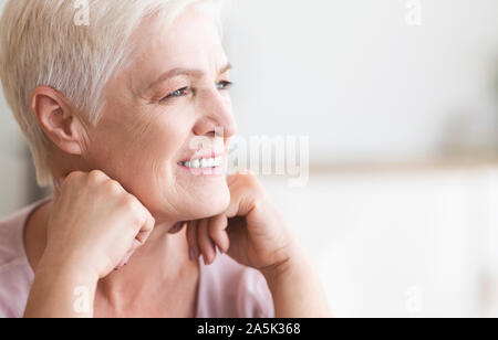 Close up of beautiful senior lady looking aside Stock Photo