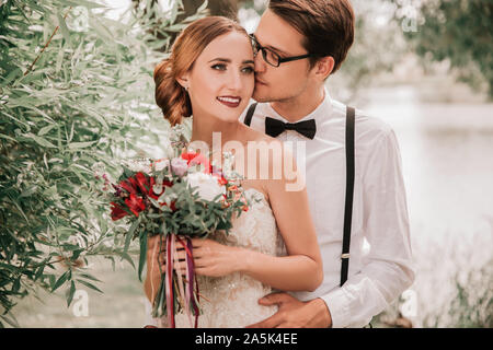 close up. happy groom kissing his bride in city Park Stock Photo