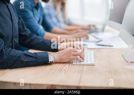 close up. group employees using computers to analyze incoming information Stock Photo